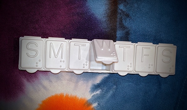 a pill organizer showing labeled days of the week. this is an accidental ingestion/poisoning risk for young kids